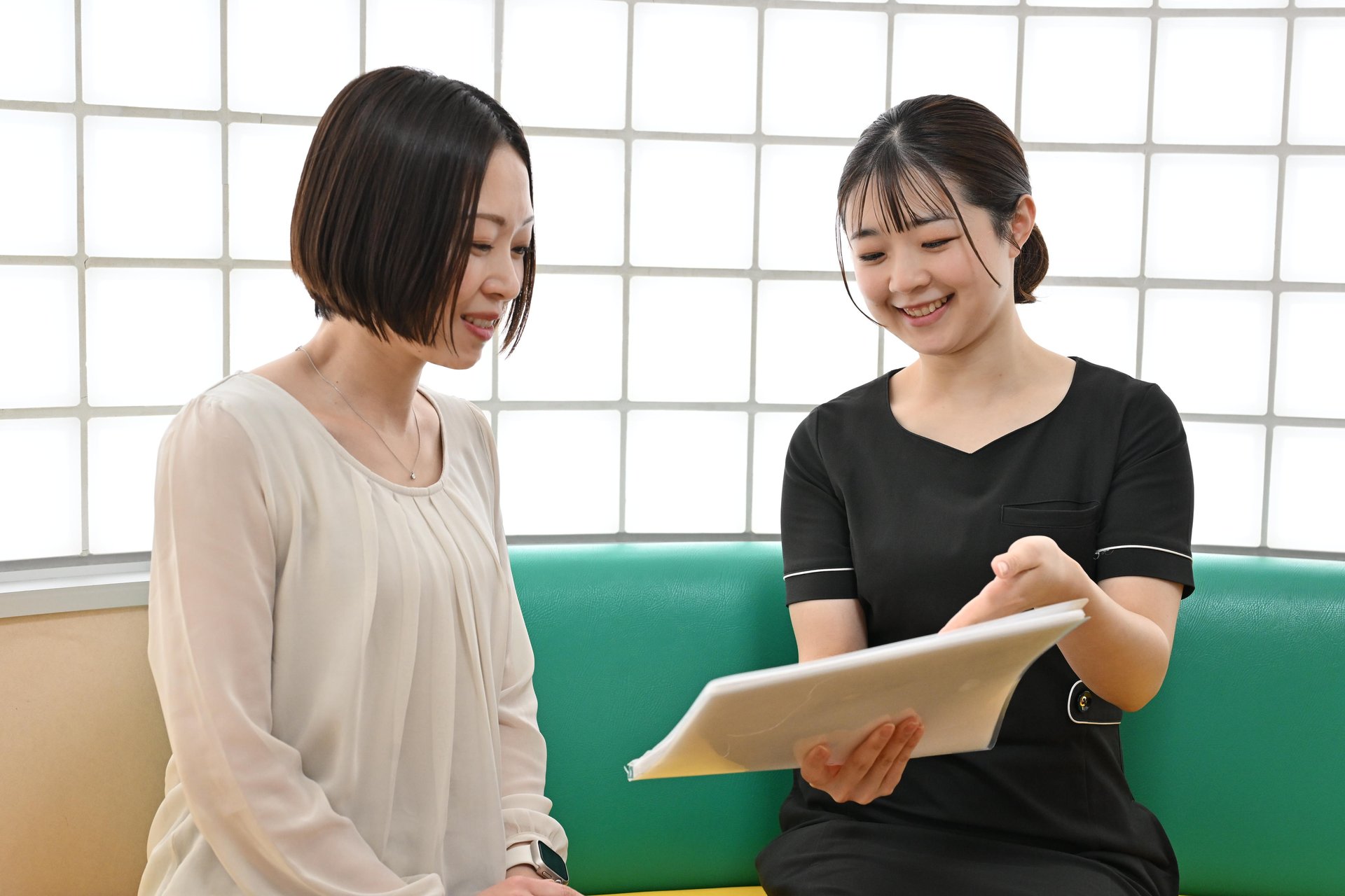 看護師が笑顔で患者の問診を行う様子