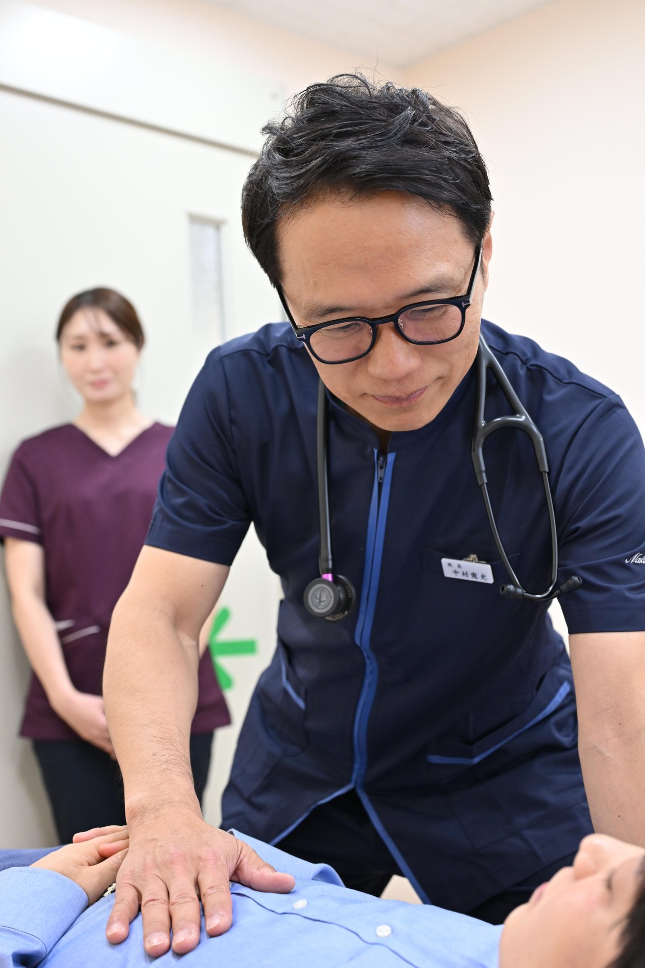 院長が患者の腹部を触診する様子
