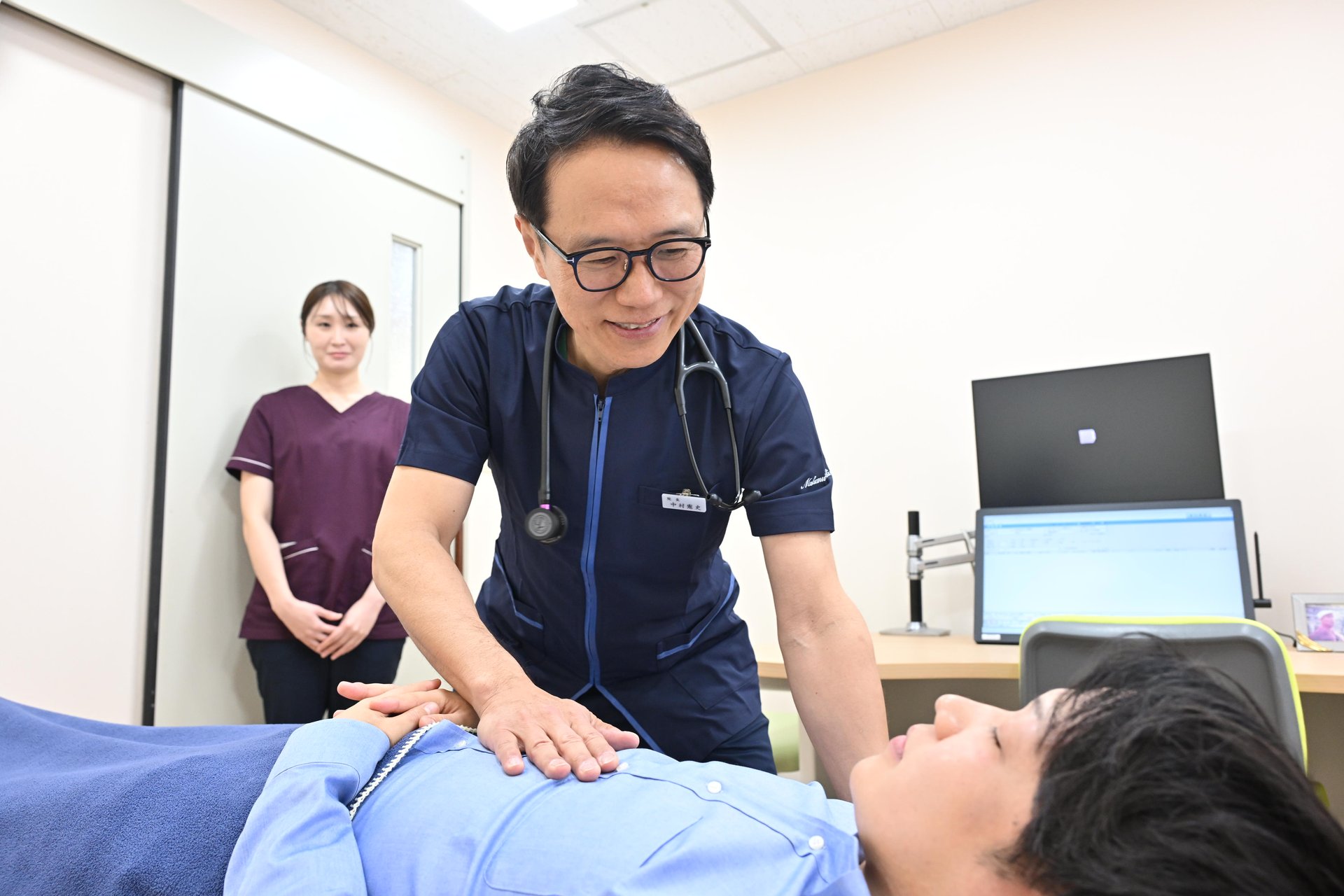 院長と看護師が患者を診察する様子